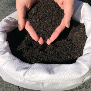 4,5 kg Regenwurmhumus in einem geöffneten Beutel präsentiert von zwei Händen
