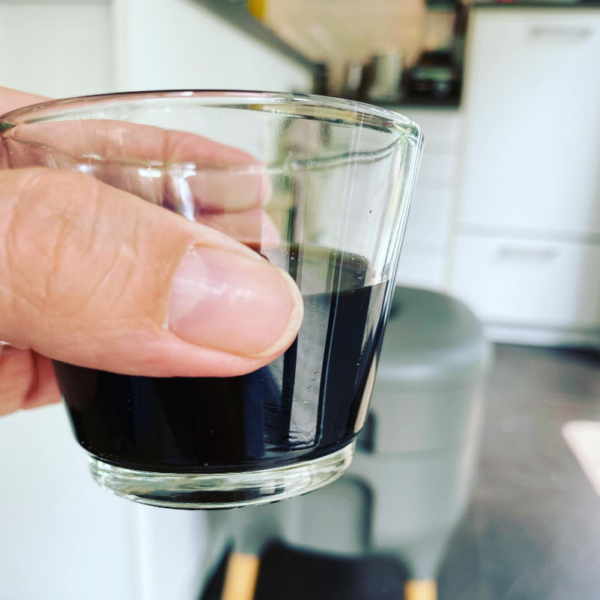 Wurmtee im Glas Ein gehaltenes Glas Wurmtee und im Hintergrund eine Wurmbox